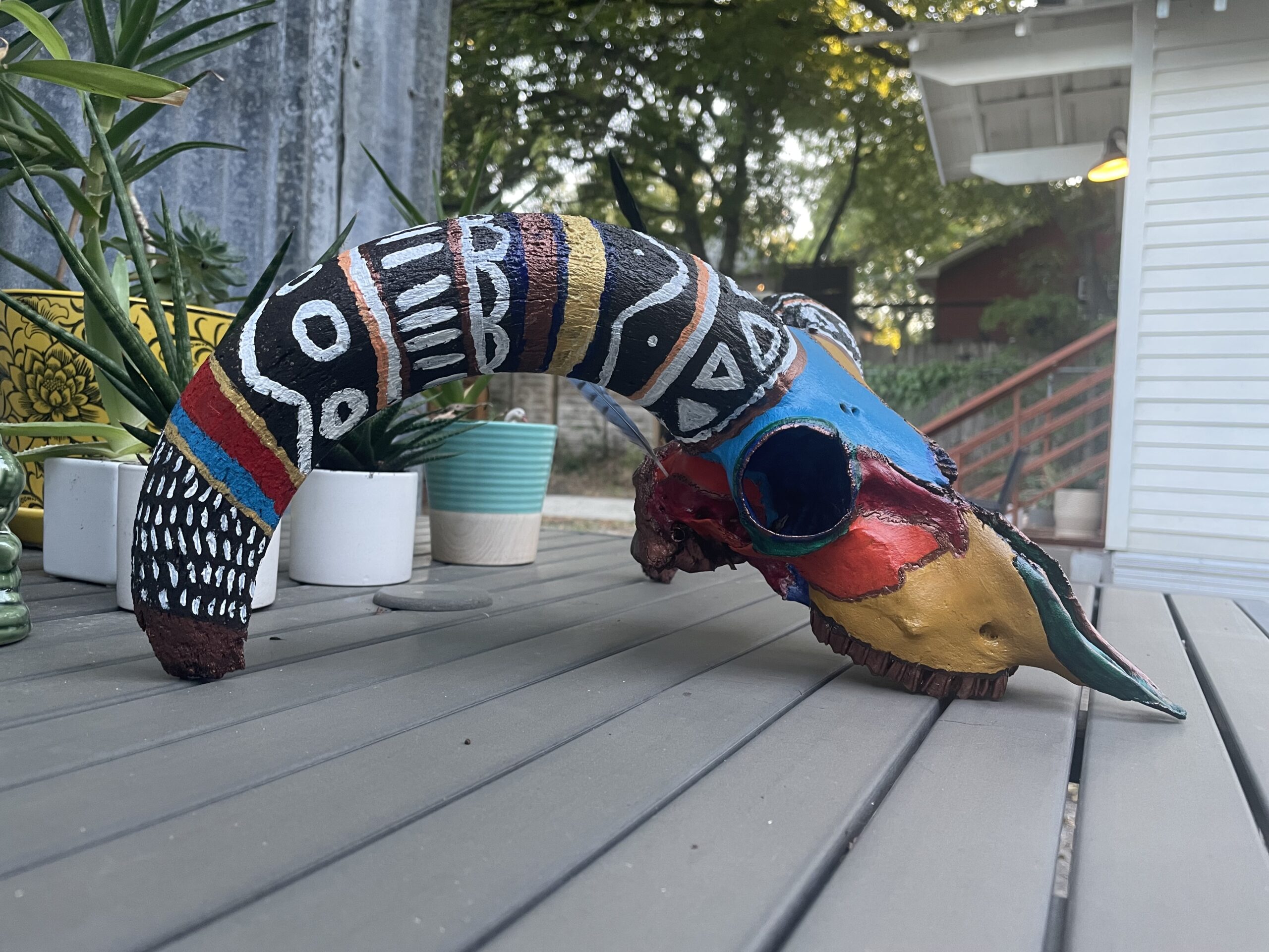 an Aoudad sheep skull painted with geometric shapes and colorful lines