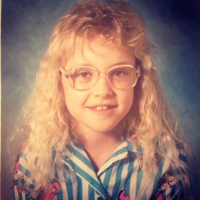 Amber as a child - pink rimmed glasses, curly blonde hair