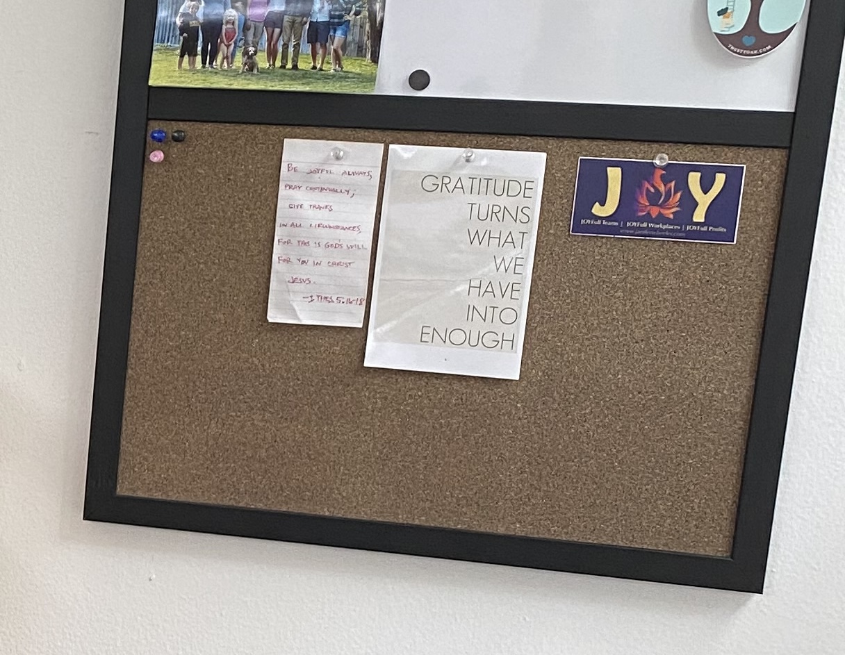 a bulletin board with the sign, Gratitude Makes What We Have Enough