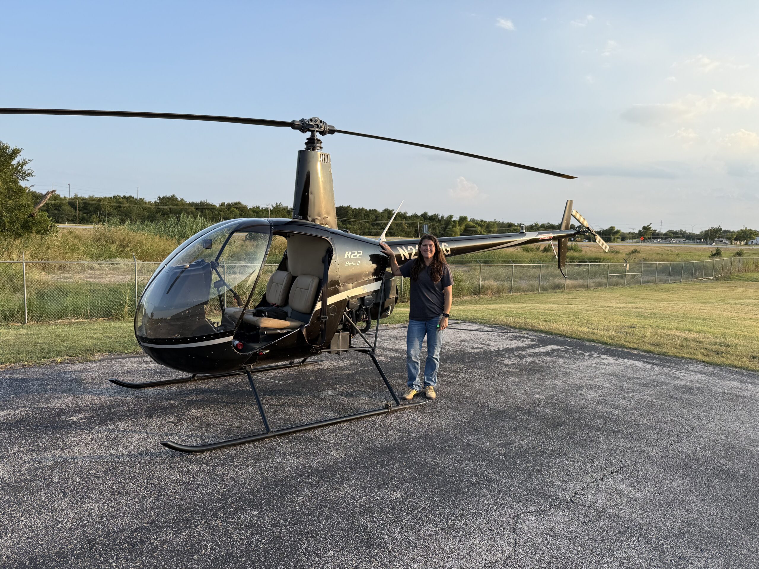 Emily standing next to a black helicopter