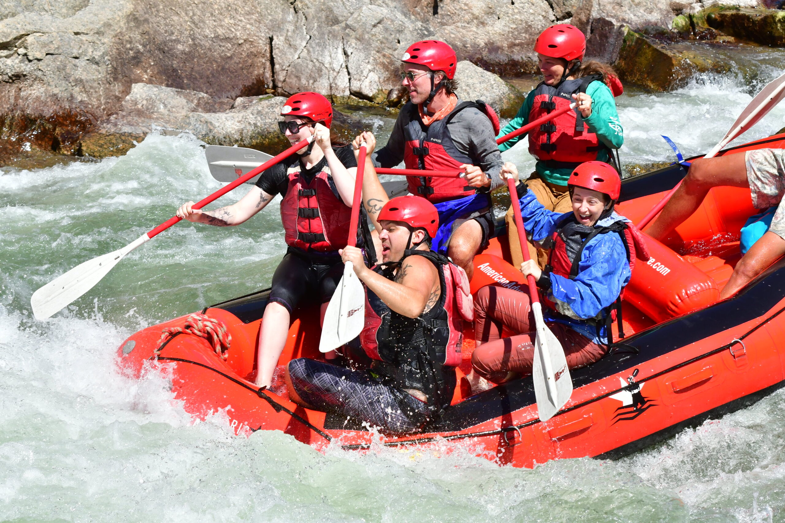 A river raft with five people in the boat; Amber is in the middle