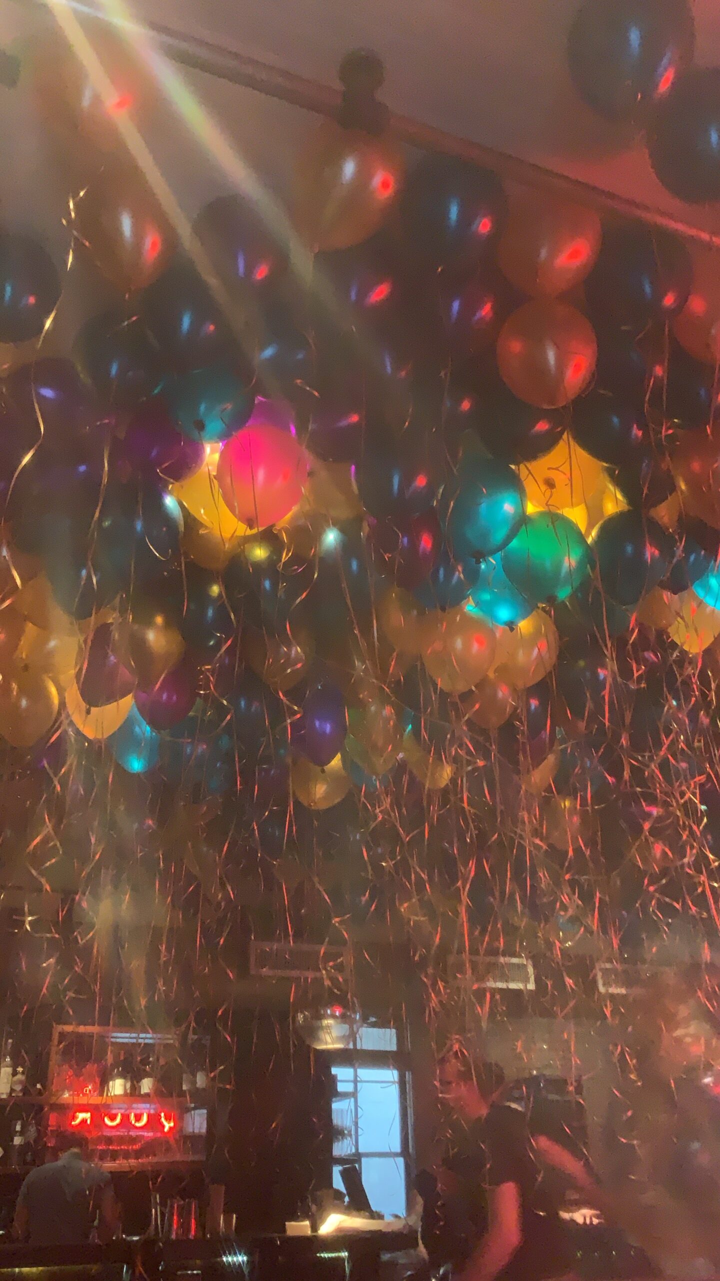 abstract photograph of a bunch of colorful balloons floating on a ceiling