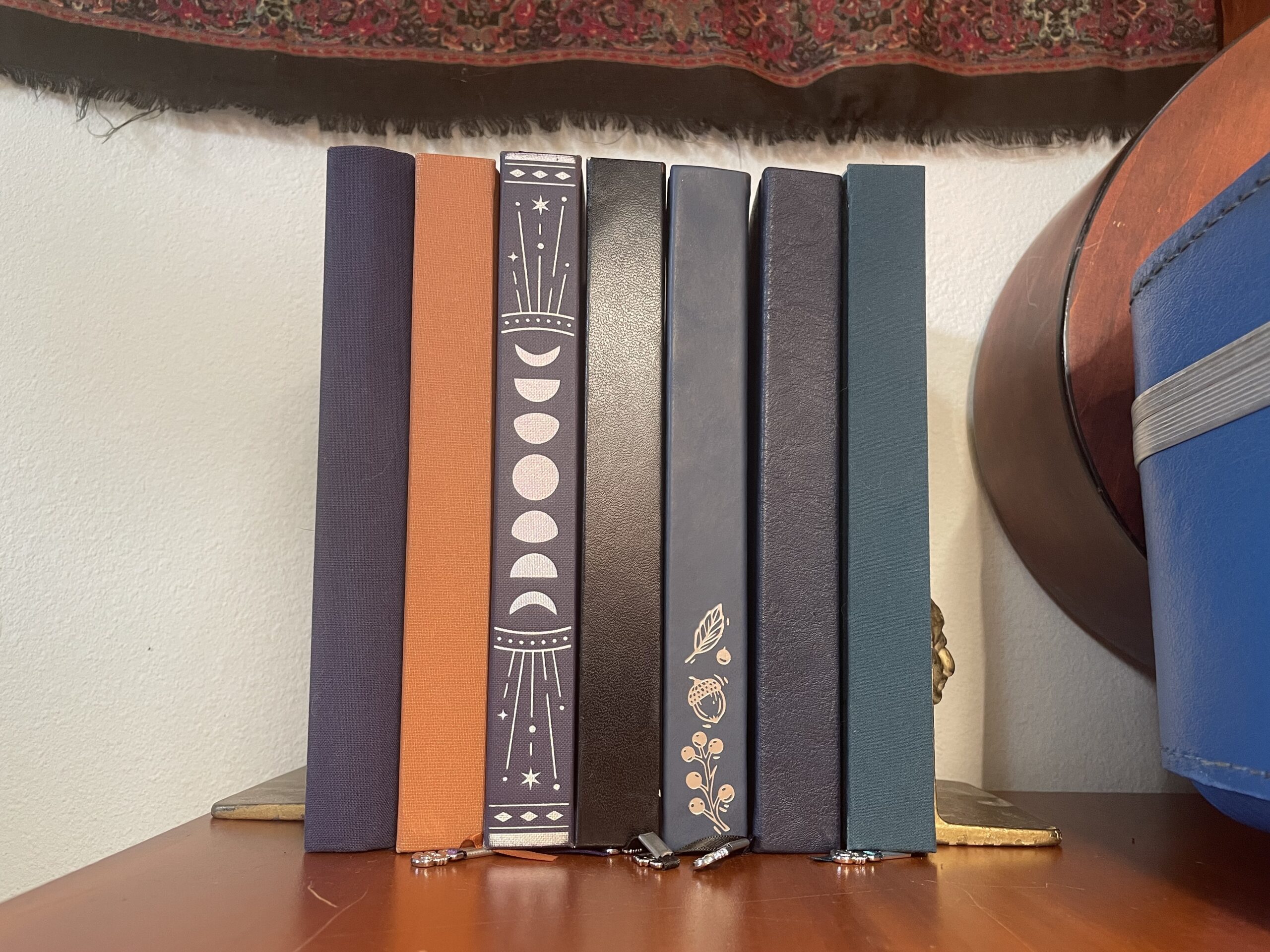 seven hardcover journals between two golden bookends
